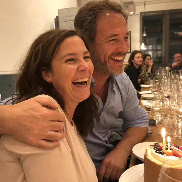 Copertina: donna ride alla sua festa di compleanno, un'amica la abbraccia